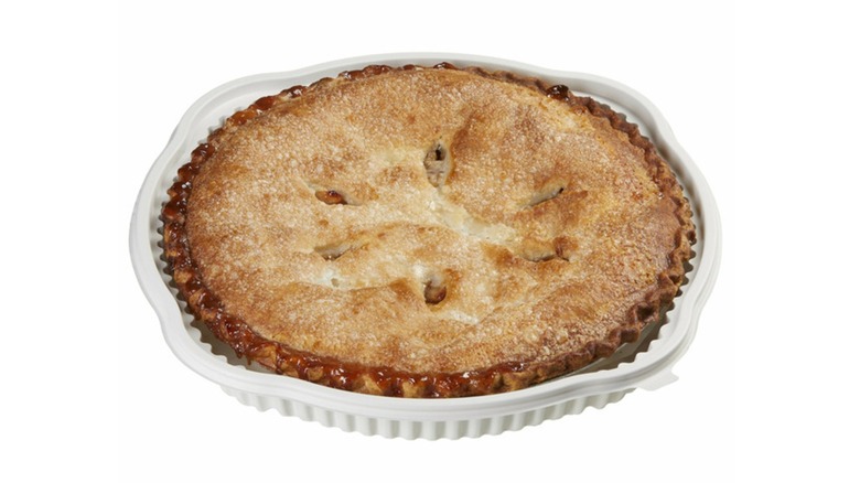 Classic apple pie in a white pie tin on a white background