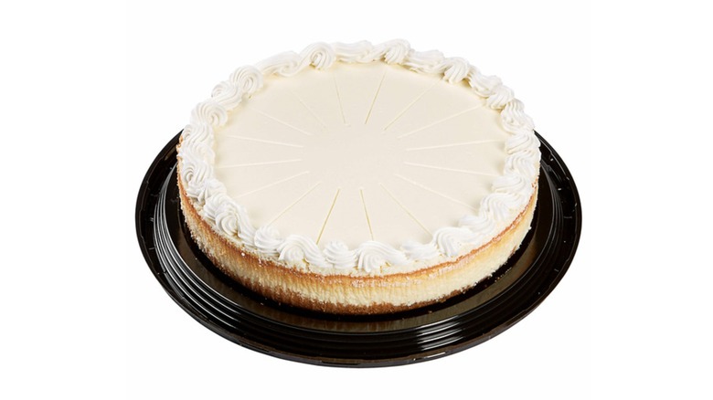 Picture of a classic cheesecake on a black platter on a white background