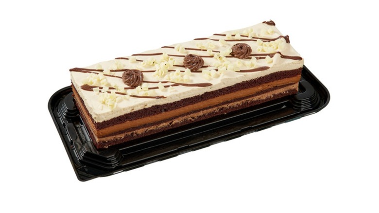 Picture of a chocolate bar cake topped with white mousse on a white background
