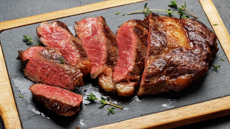 Sliced steak on cutting board