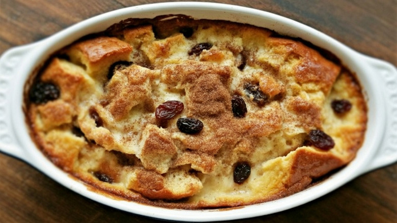 bread pudding topped with raisins in a white oval dish