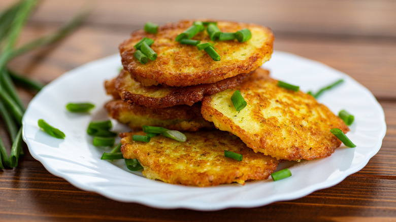 potato pancakes topped with chives on white plate