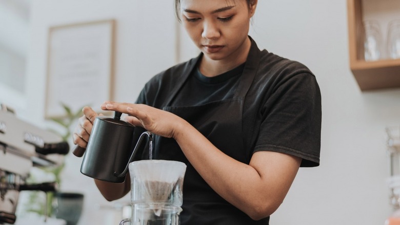 a barista in the middle of a pour-over