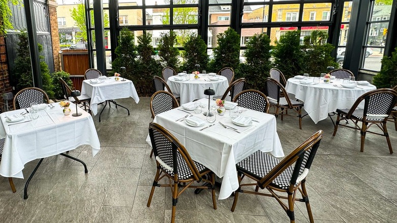 Several dining tables with white cloths in Ristorante Lombardo