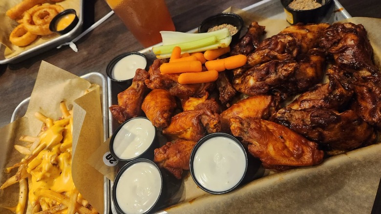 Tray of chicken wings with dipping sauce, celery, and carrots