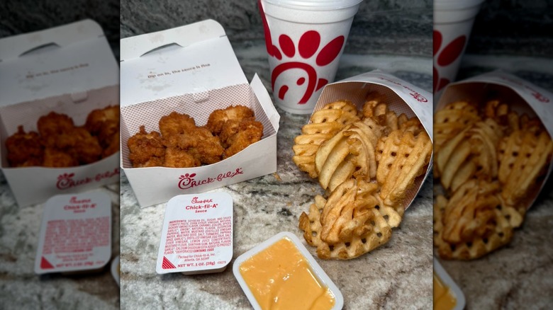 Chicken nuggets, waffle fries, soda, and Chick-fil-A sauce on a marble countertop