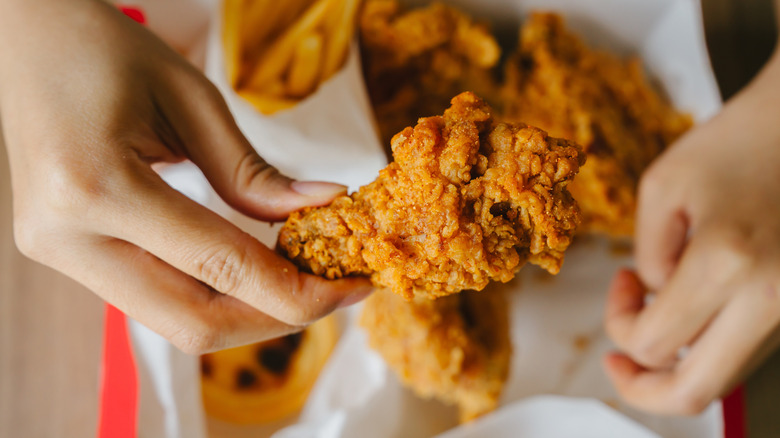 person holding a fried chicken drumstick