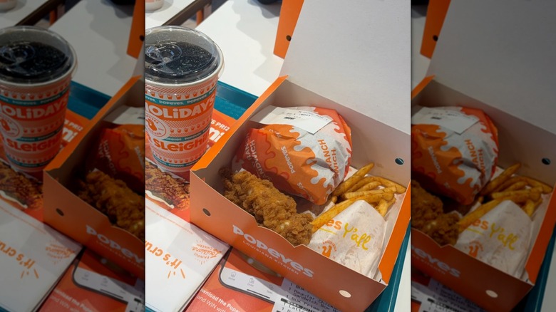 Popeye's meal in an orange box with an orange cup of soda