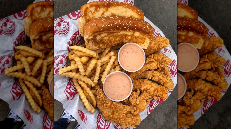 French fries, chicken tenders, dipping sauce, and Texas toast in a fast-food basket