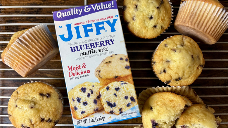 A box of Jiffy blueberry muffin mix and baked muffins