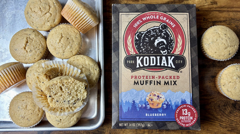 A box of Kodiak Protein-Packed Blueberry muffin mix and baked muffins