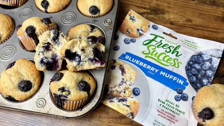 A package of Concord Food's Fresh Success Blueberry muffin mix with a muffin pan of freshly baked muffins
