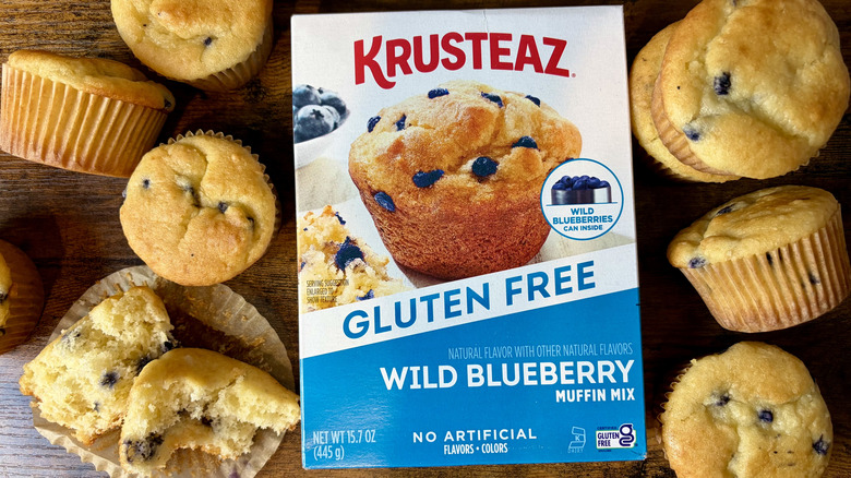 A box of Krusteaz Gluten Free Wild Blueberry Muffin Mix with baked muffins