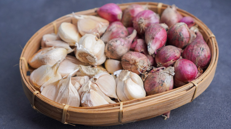 basket of onions and garlic on kitchen counter