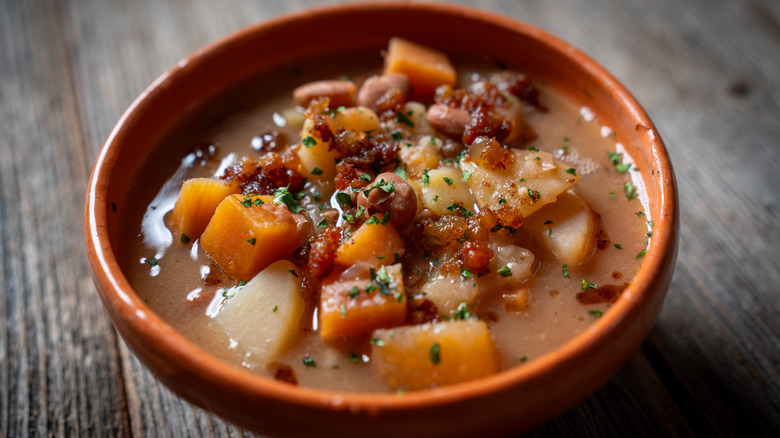 A bowl of stew featuring cubes of root vegetables and other ingredients in brown broth