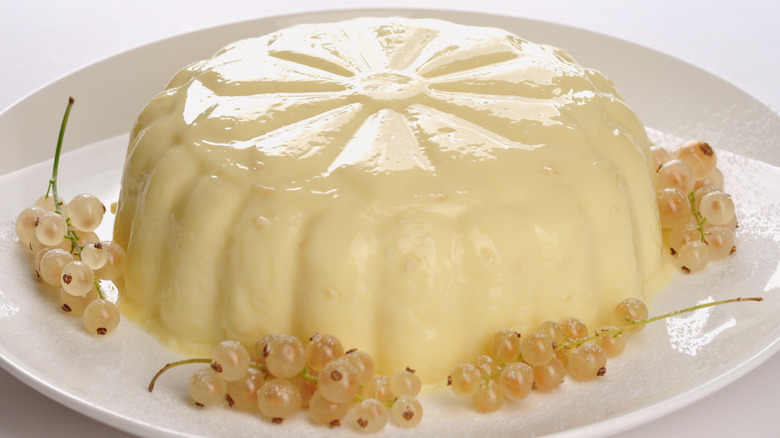 molded blancmange on plate with white currants