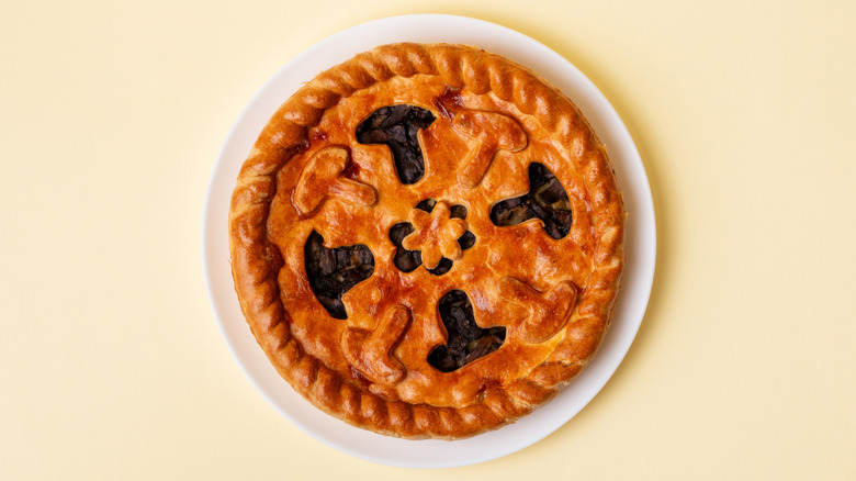 view of pie from above with decorative mushroom cutouts on the crust