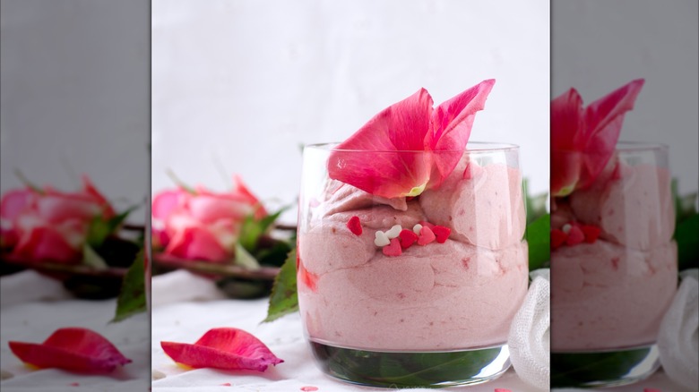 glass of pink pudding topped with rose petals