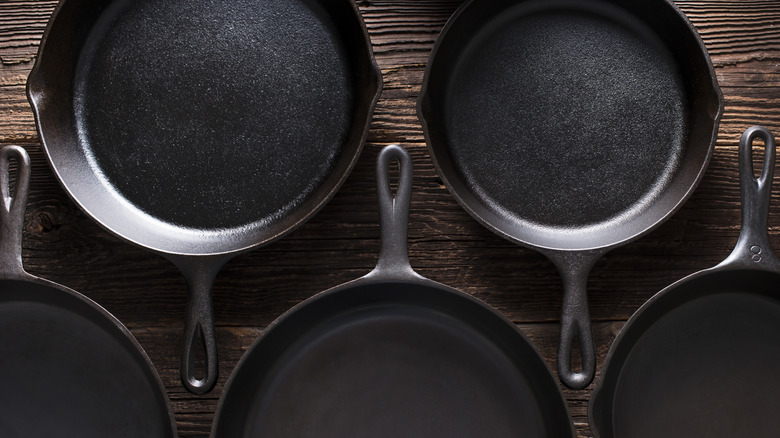 overlay photo of cast iron skillets on a wooden table