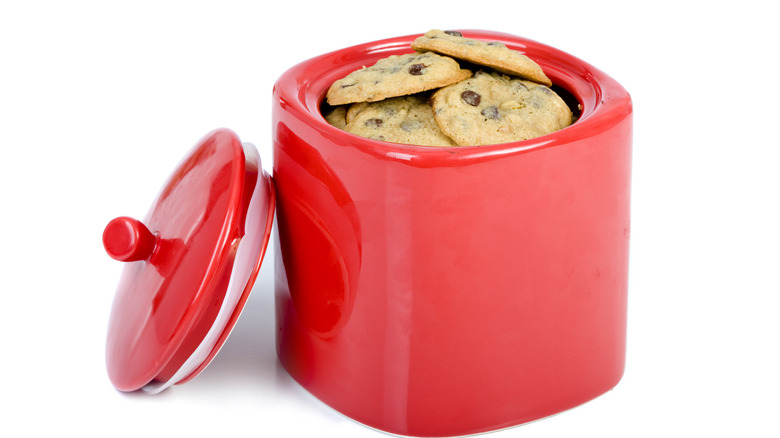 red ceramic cookie jar filled with chocolate chip cookies