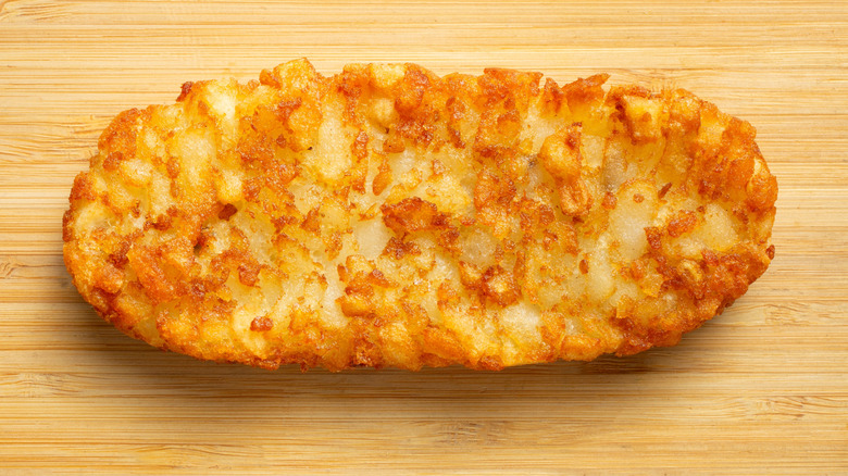 A single McDonald's hash brown on wooden surface