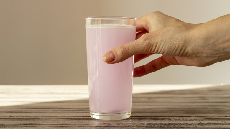 Person holding pink electrolyte drink