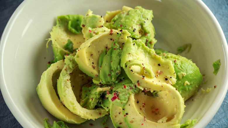 Avocado pieces in a ceramic bowl topped with spices
