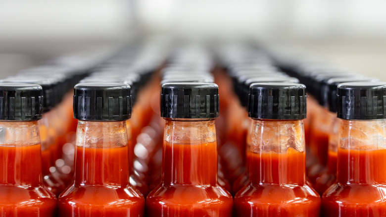 Five rows of hot sauce, showing the top of the bottle and cap