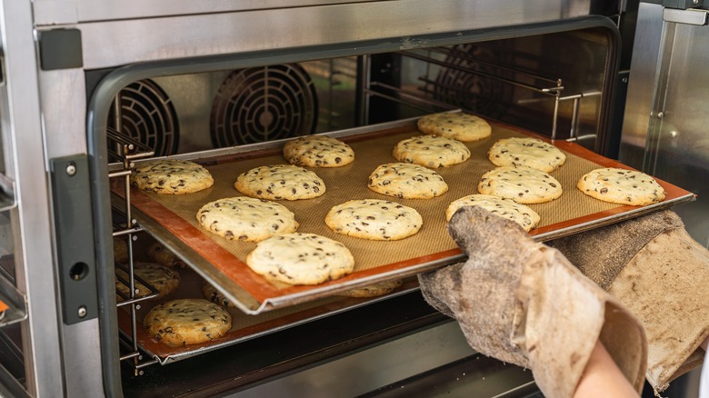 Cookies on silicone baking mat being taken out of oven