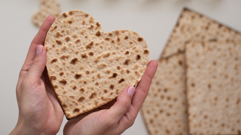 Woman's hands holding heart-shaped matzo