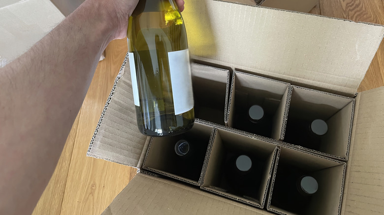 Person unpacking a six-pack half case of wine