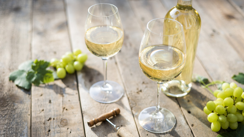 White wine bottle, glasses and grapes