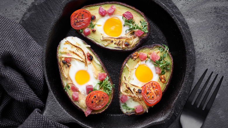 eggs baked in avocados with tomatoes and herbs