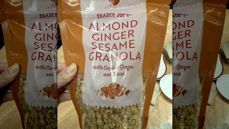 Hand holds a bag of Trader Joe's Almond Ginger Sesame Granola