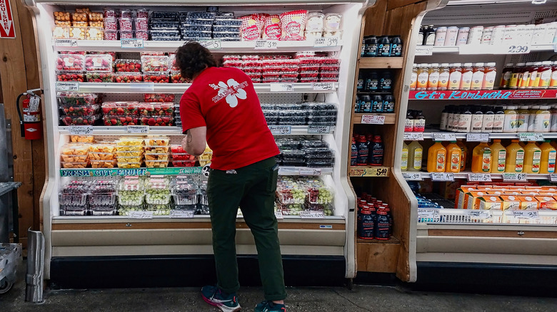 Trader Joe's employee stocks a refrigerated case.
