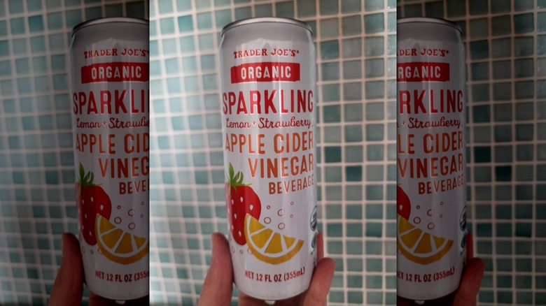 Hand holds a can of Trader Joe's Organic Sparkling Apple Cider Vinegar Beverage