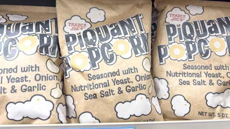 Bags of Trader Joe's Piquant Popcorn sit on a store shelf