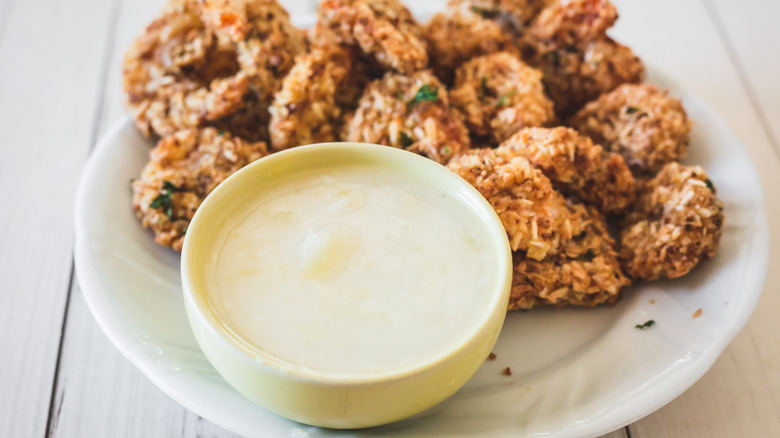 plate of coconut shrimp with bowl of dipping sauce