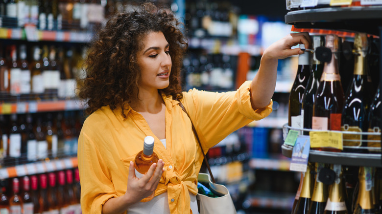 A young woman shopping for alcohol in a store