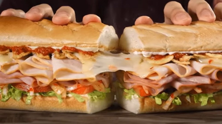 hands holding Firehouse Hot Ones subs