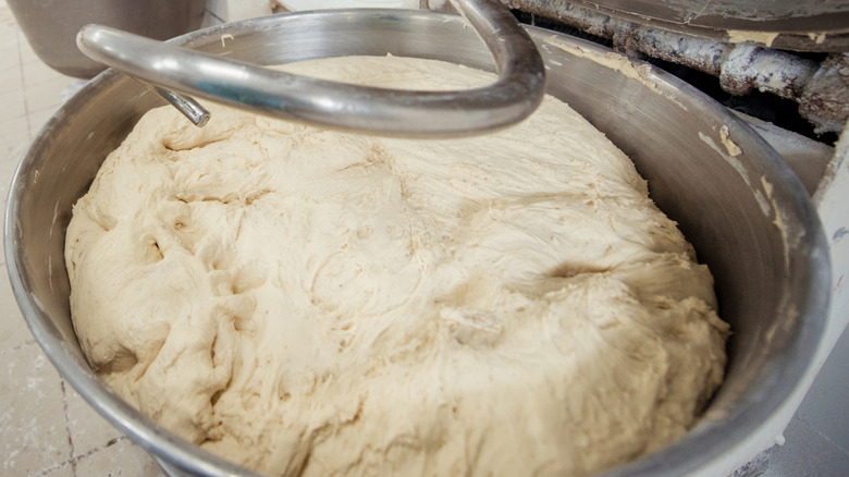 A close-up of bread dough in the bowl of a stand mixer
