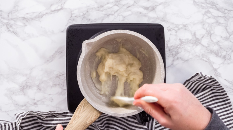 An overhead shot of a person cooking flour and milk for tangzhong