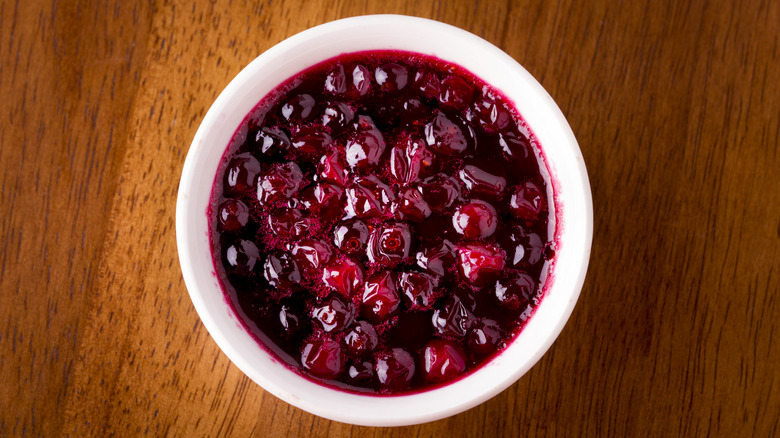 Bowl of cranberry sauce on wooden table