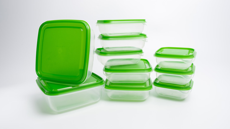 Clear, plastic food organizers with green lids on a white background
