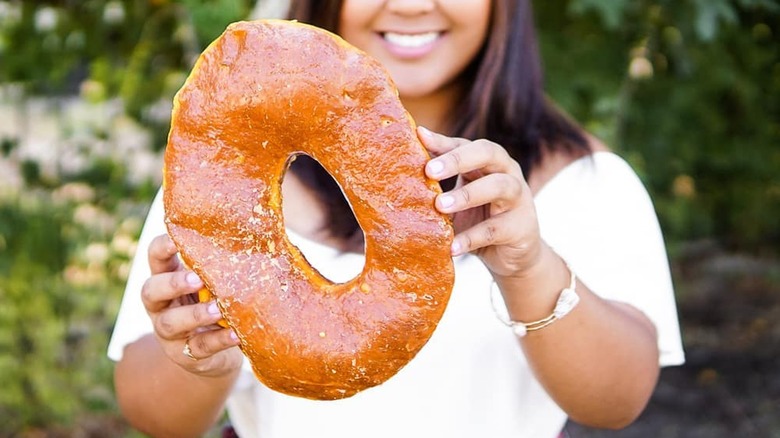 woman holding Round Rock Donut