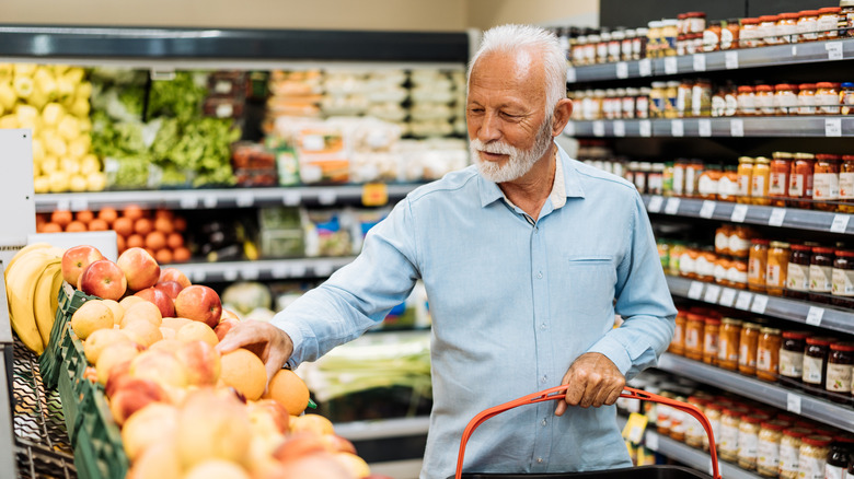an older man with gray hair is grocery shopping