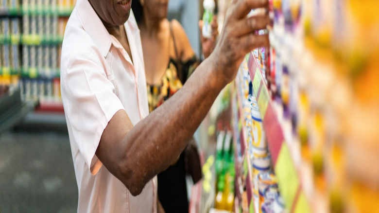 older gentleman with gray hair shopping for yogurt