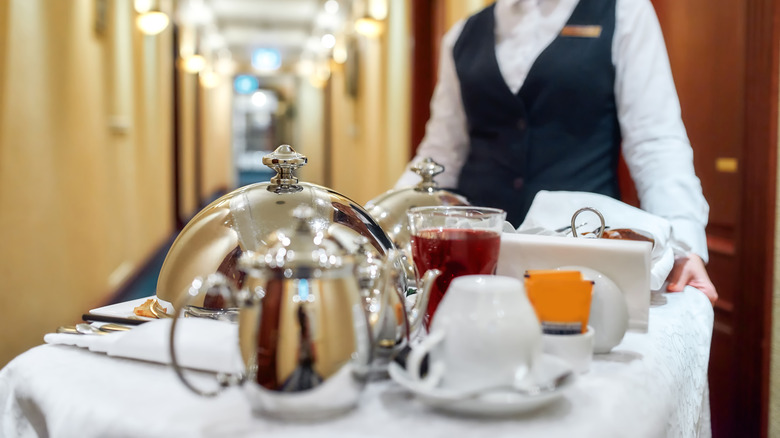 Hotel worker pushing room service tray