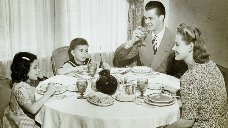 Vintage photo of family of four eating soup at a dining table