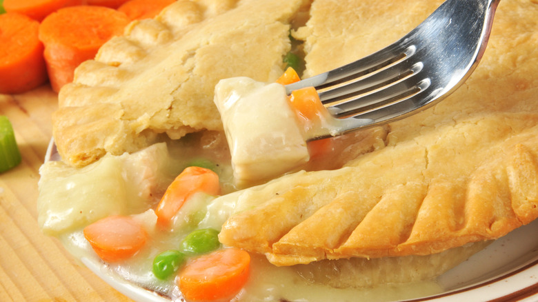 A fork taking a bite out of a chicken pot pie